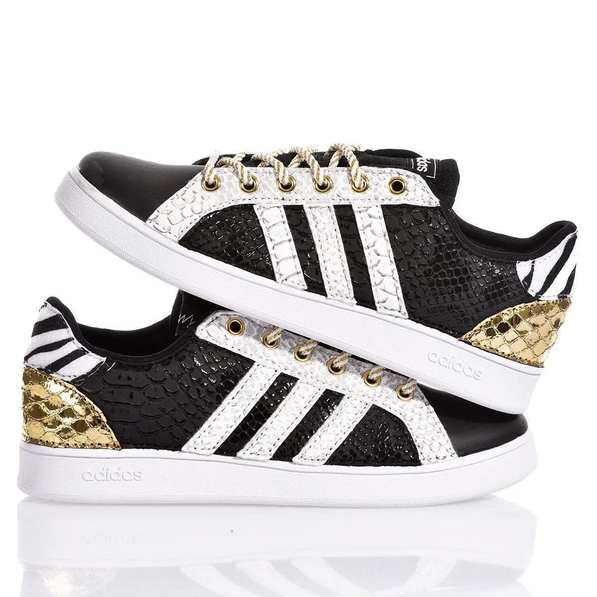 Sneakers customizzate nere e bianche con dettagli dorati e texture serpente, stile unico artigianale
