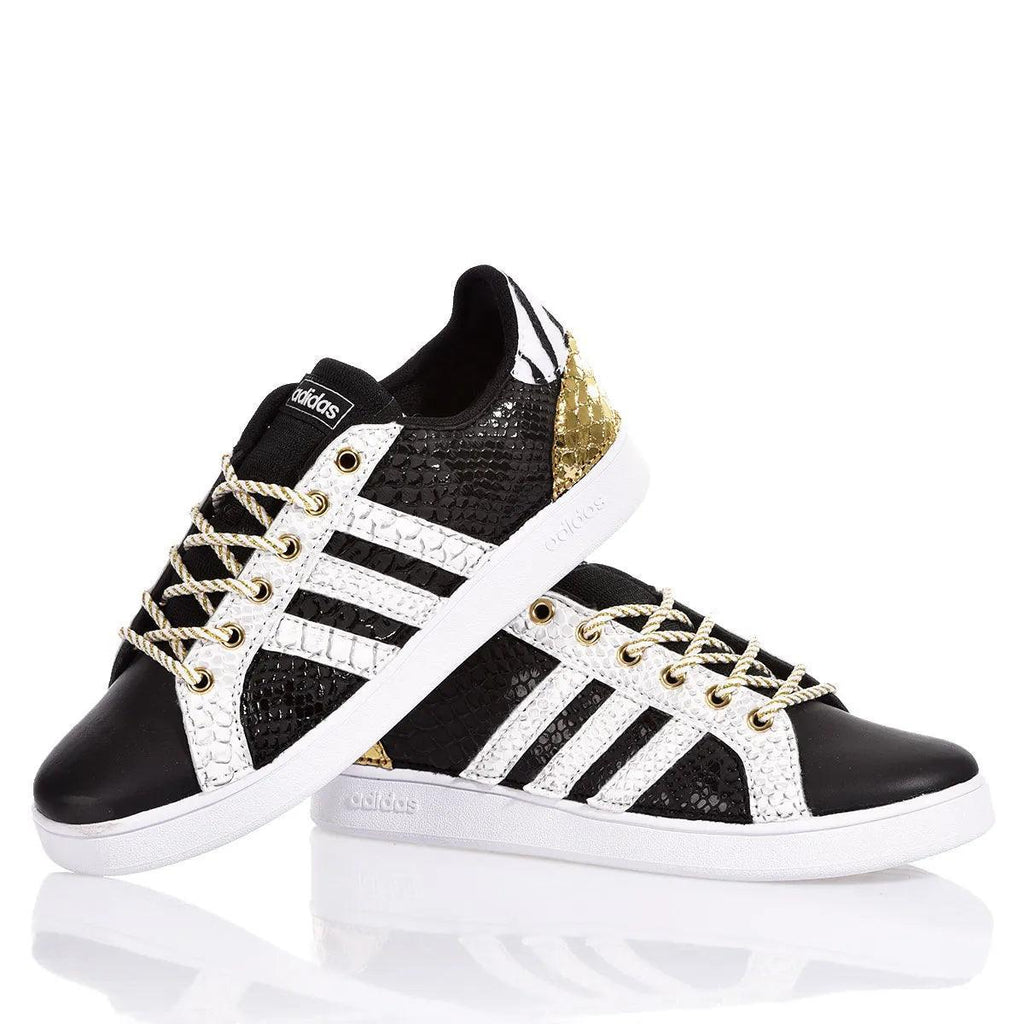 Sneakers customizzate nere e bianche con dettagli dorati e lacci intrecciati